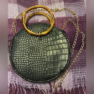 Black Croc-Embossed Round Bag with Bamboo Handle and chain strap.